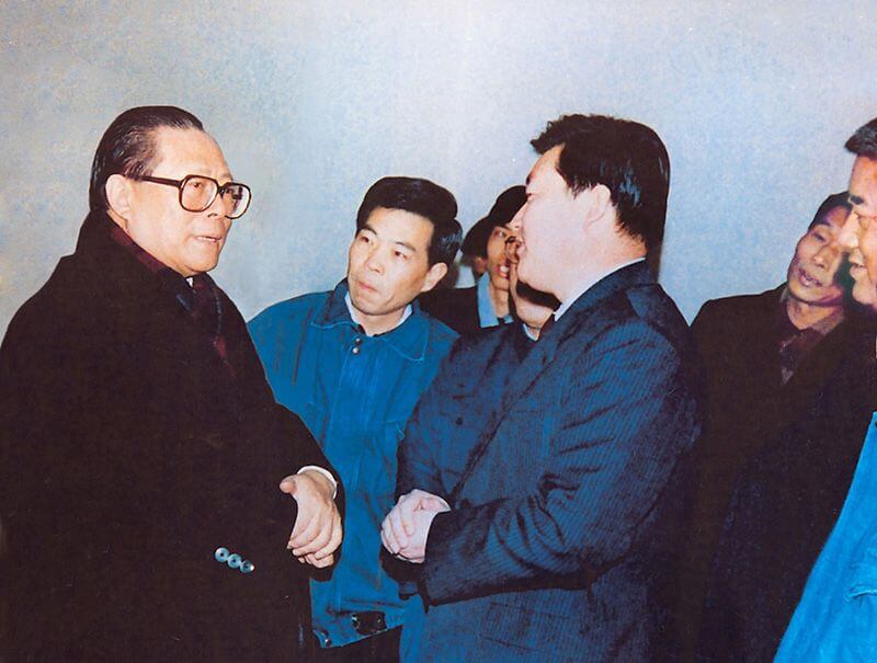 1991年2月5日，时任中共中央总书记的江 泽 民（左一）视察利来国际，他指示：“抓住机遇，深化改革，扩大开放，促进发展，保持稳定。”